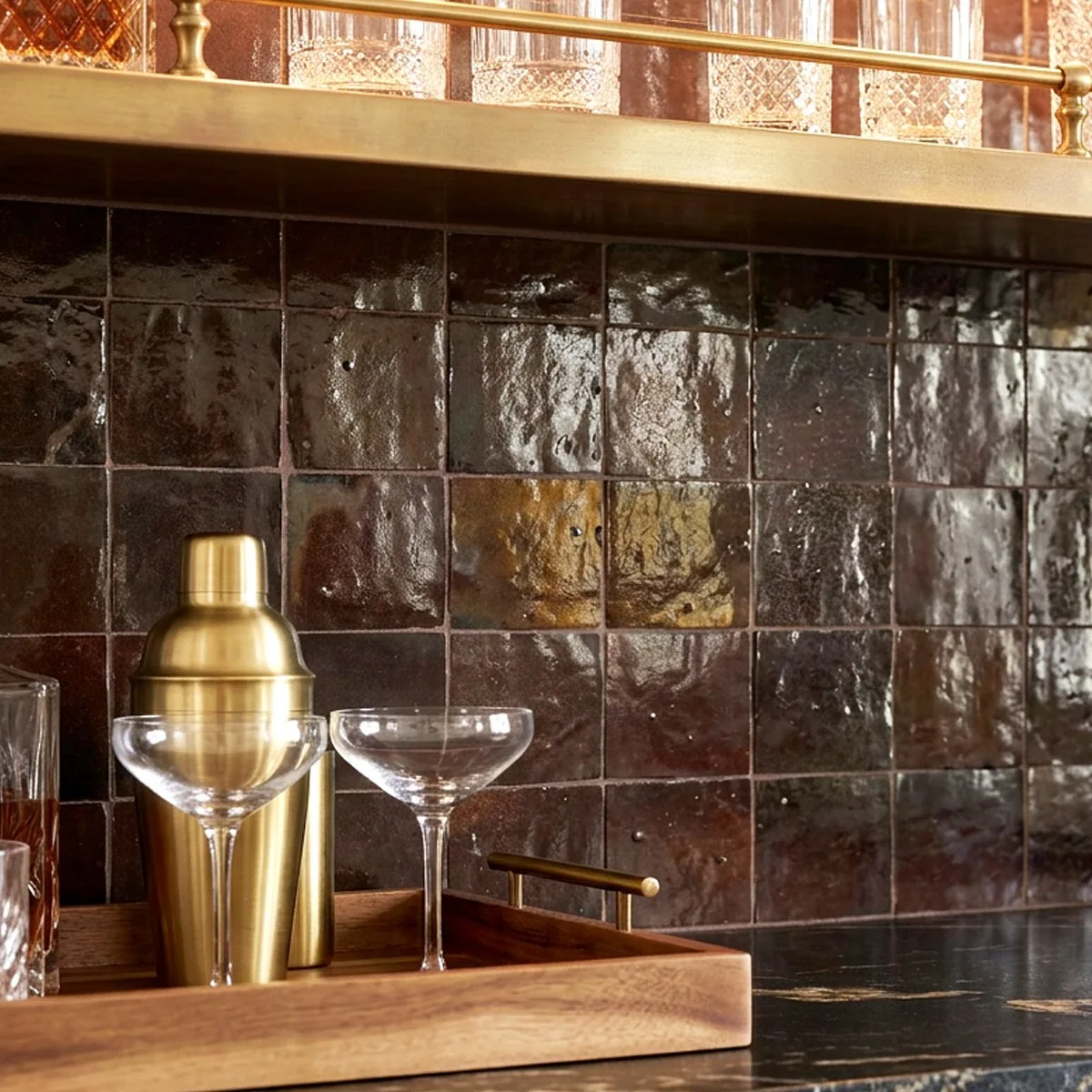 Photoreal detail of the bar: glazed brown zellige tile, brass shelf rail, coupe glasses and a brass shaker